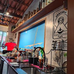 Balcão do café Oráculo com máquina de espresso e decoração artesanal